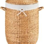 Round woven laundry basket with lid, lined and with concealed handle, suitable for household clothing storage